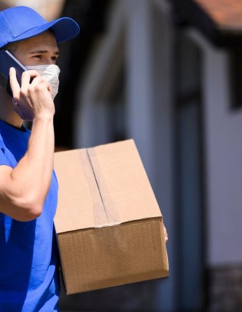 delivery-man-with-face-mask-carrying-parcel_23-2148579139